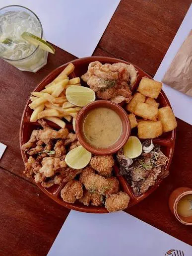 Roleta Amazônica: travessa redonda com vários peixes fritos, macaxeira, batata frita, limão e molho no centro